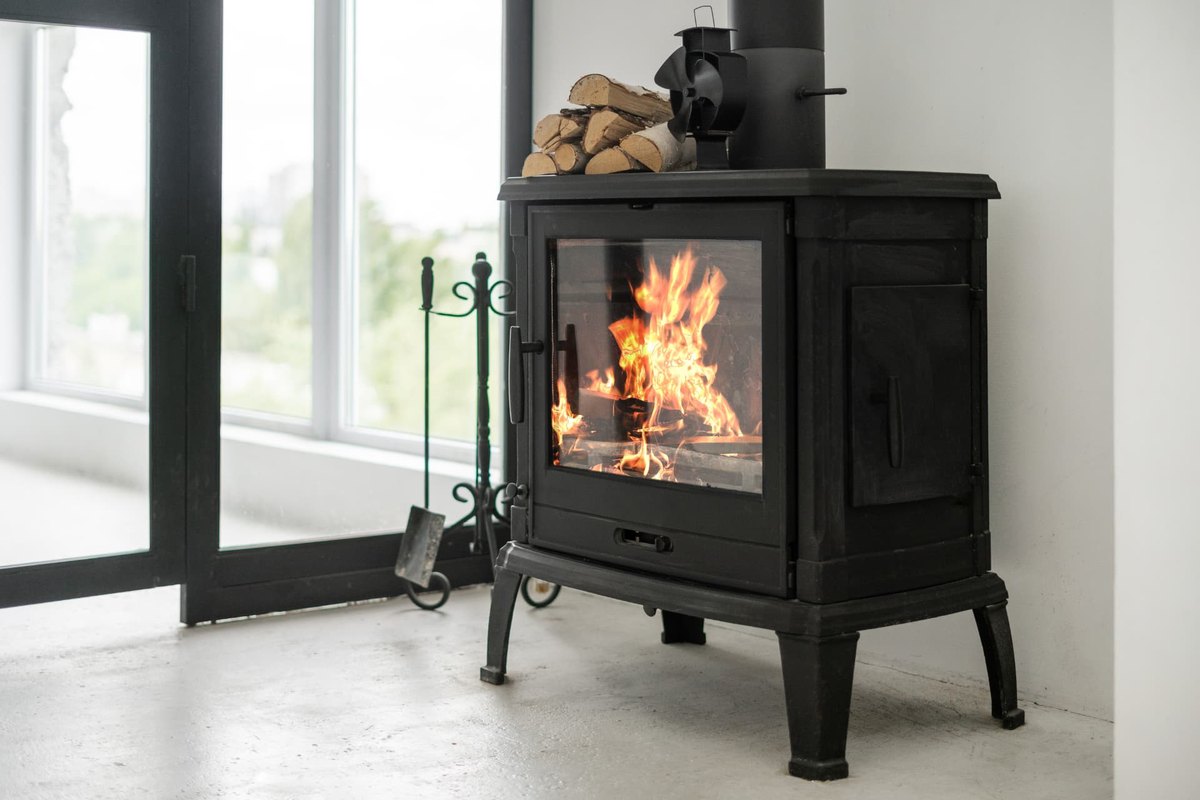 Wood stove with a fire burning and clear space kept around the appliance